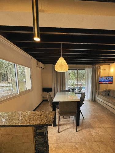 a dining room with a table and chairs in a room at Sonidos Del Bosque in Mar de las Pampas