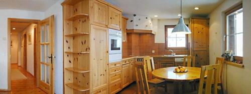 a kitchen with wooden cabinets and a wooden table at Curtin Sot 15A in Sent