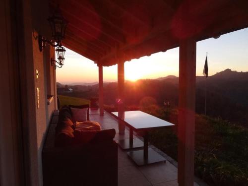 a porch with a table and a couch and the sunset at Haus Am Sternsberg in Sternenberg