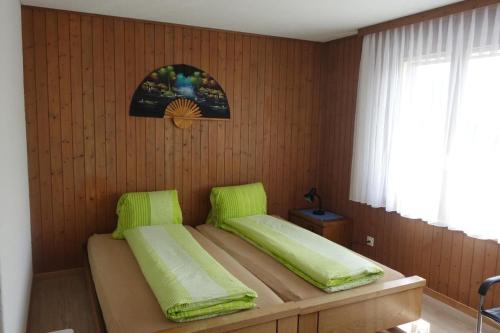a bedroom with a bed with green cushions on it at Ferienwohnung Kathriner Durrer in Sarnen