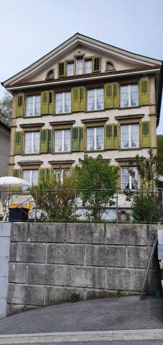 ハイデンにあるGloriosの建物に緑色のシャッター付き窓がある大きな建物