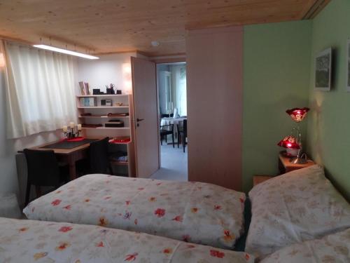 a bedroom with two beds and a desk and a dining room at Haus Am Sternsberg in Sternenberg