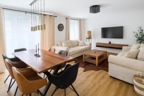a living room with a table and chairs and a couch at Elegance Suites Leipzig in Leipzig