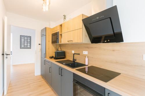 a kitchen with a sink and a flat screen tv at Elegance Suites Leipzig in Leipzig