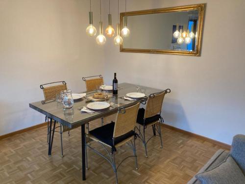 a dining room table with chairs and a mirror at Appartamento D Oro in Ruvigliana