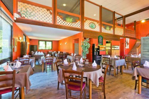 a restaurant with tables and chairs in a room at Logis Albhotel Grill in Alby
