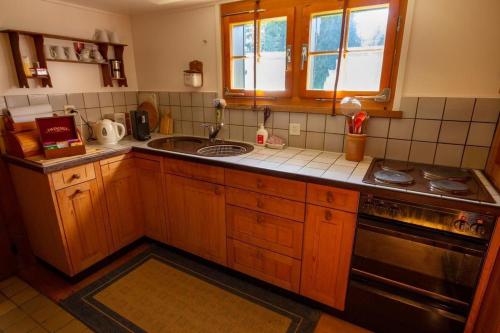a kitchen with a sink and a stove at Ferienhaus Fromsenrüti in Walzenhausen