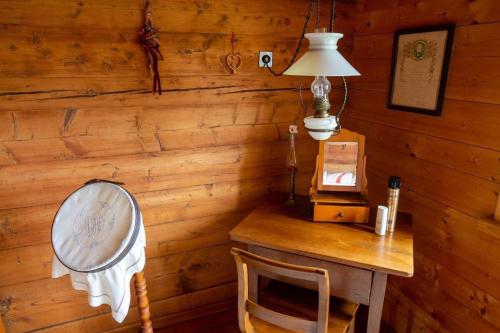 a room with a wooden wall with a table and a lamp at Ferienhaus Fromsenrüti in Walzenhausen