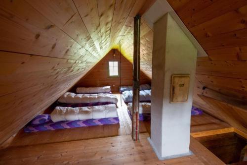 an attic room with beds in a wooden cabin at Ferienhaus Fromsenrüti in Walzenhausen