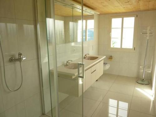a bathroom with a glass shower and a sink at Oberwilen in Vitznau