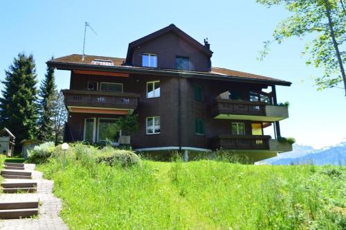 a large house on top of a hill at Haus Ahorni in Beatenberg