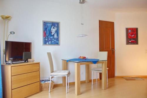 Habitación con mesa con 2 sillas y TV. en Chardun, en Celerina
