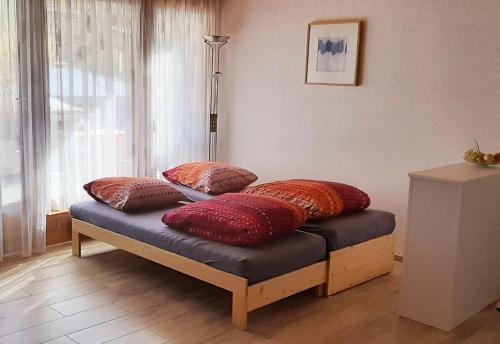 a bench with pillows on it in a room at Rothorn Center A 1Og Schöpfer in Sörenberg
