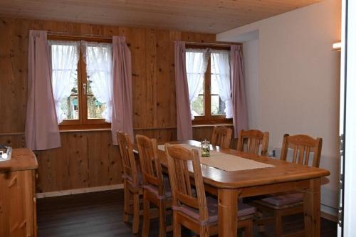Un comedor con mesa y sillas de madera. en Bauernhof Sal, en Bütschwil