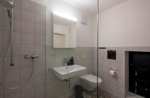 a bathroom with a sink and a toilet and a shower at Schloss Heidegg in Gelfingen