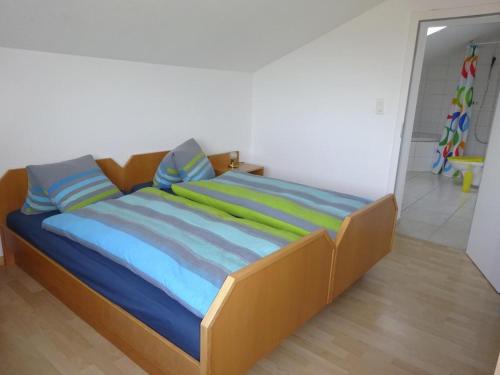 a bed with colorful sheets and pillows in a room at Rehalp Osten in Bischofszell