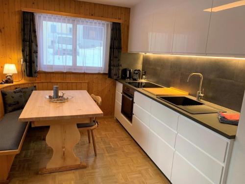 a kitchen with a wooden table and a sink at Chesa Talvo in Samedan