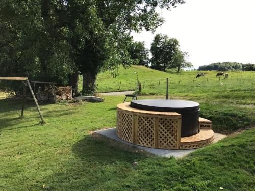 a fire pit in a field with cows in the background at Ferme D Alma in Ocourt