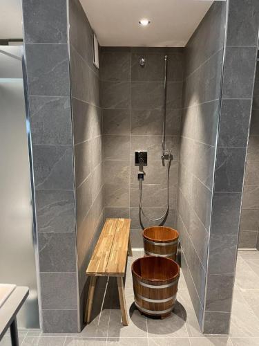 a bathroom with a shower with a wooden tub and a bench at Ferme D Alma in Ocourt