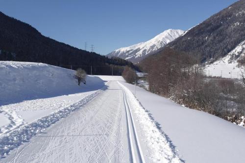 a road covered in snow with mountains in the background at Ers Curtins in Zernez
