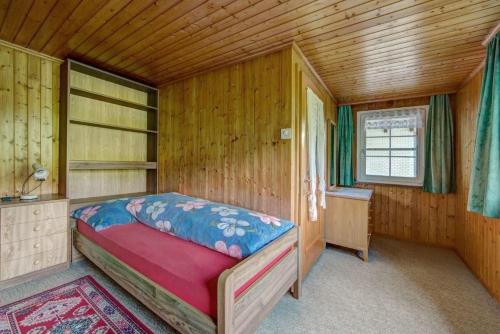 a bedroom with a bed in a wooden room at Ferienwohnung Hautle in Gais
