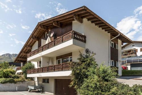 a house with a wooden balcony on top of it at Casa La Roda Heidi in Sedrun