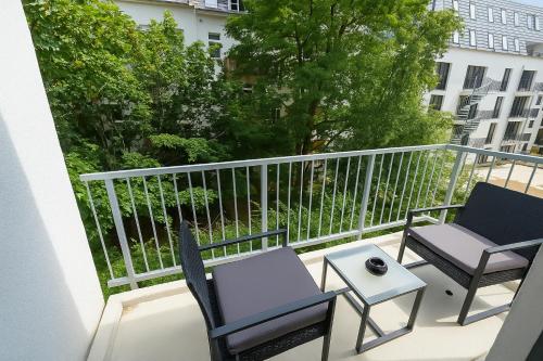 two chairs and a table on a balcony at Elegance Suites Leipzig in Leipzig