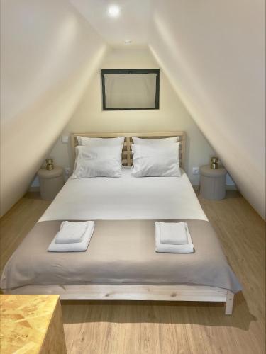a bedroom with a bed with two towels on it at Chalés Luna in Rio Chalé Lua in Ponte da Barca