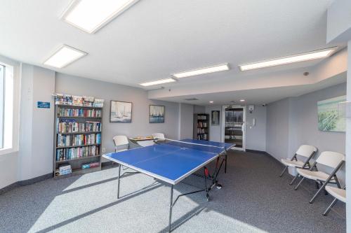 a ping pong table in a room with chairs at On the Beach-2/Br 2/Bath, 26th floor! Spectacular views of Ocean & River in Daytona Beach Shores