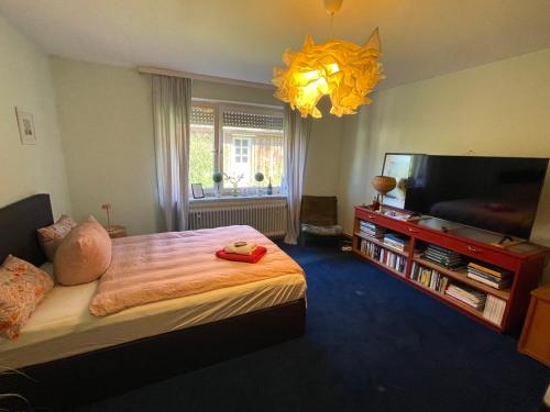 a bedroom with a bed and a flat screen tv at Haus am Waldrand in Wrestedt