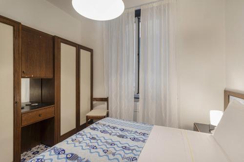a bedroom with a bed and a desk and a lamp at La Casa di Nonno Sallù by Wonderful Italy in Camogli