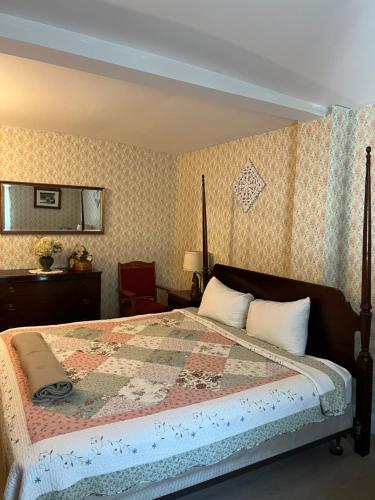 a bedroom with a bed with a quilt on it at Old Orchard Beach Inn in Old Orchard Beach