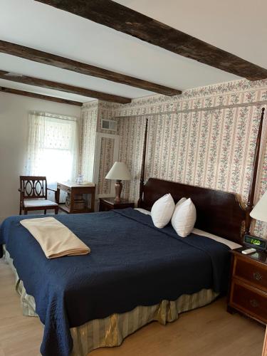 a bedroom with a large bed with a blue blanket at Old Orchard Beach Inn in Old Orchard Beach