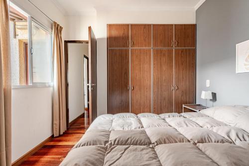 a bedroom with a large bed and a wooden cabinet at Complejo Abaurrea in Mendoza