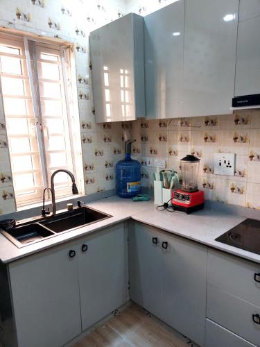 a kitchen with white cabinets and a sink and a window at 3 bedroom Apartment lekki Victory Homes in Mama