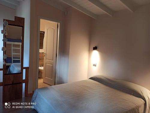 a bedroom with a bed and a light on the wall at Duplex Luna in Pinamar