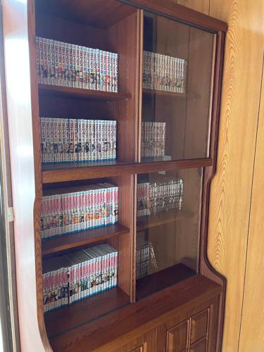 a wooden cabinet filled with lots of dvds at Tomaru細野 in Nobezawa