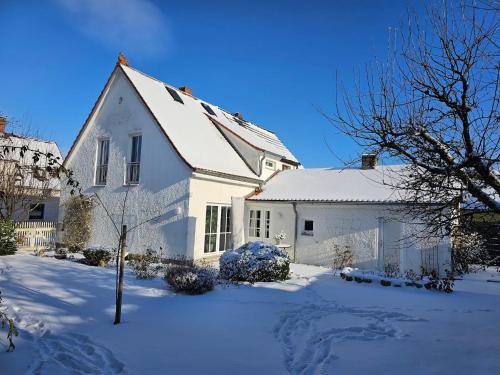 een wit huis met sneeuw op de grond bij Ferienhaus Rosengarten in Selb