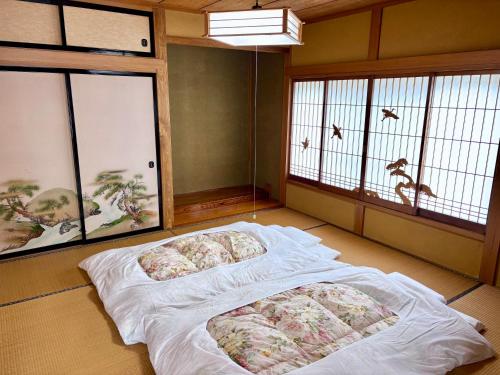 a room with two beds in a room with windows at Tomaru細野 in Nobezawa