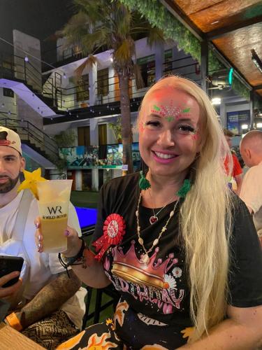 a woman with paint on her face holding a drink at Wild Rover Huacachina in Ica