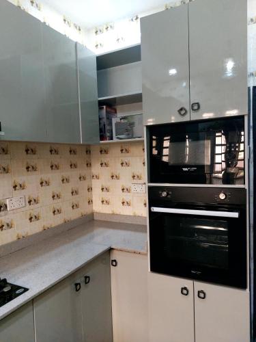 a kitchen with white cabinets and a black oven at 3 bedroom Apartment lekki Victory Homes in Mama