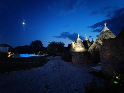 a castle at night with the moon in the sky at Trullo Amalia con piscina privata in Latiano