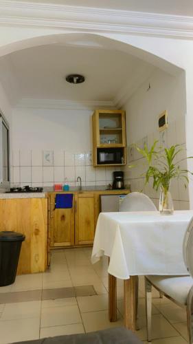 a kitchen with a table with a white table cloth on it at Résidence Hôtelière l'Océane in Kribi