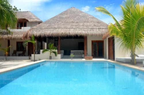a swimming pool in front of a villa at Tierra del Mar Hotel - Adults Only in Holbox Island