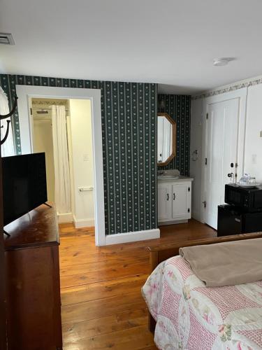 a bedroom with a bed and a table and a mirror at Old Orchard Beach Inn in Old Orchard Beach