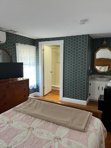 a bedroom with green wallpaper and a bed and a mirror at Old Orchard Beach Inn in Old Orchard Beach