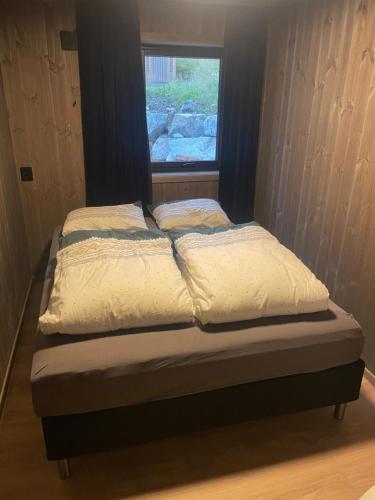 una cama en una habitación con ventana en Flott hytte i Sogndal skisenter-Hodlekve, en Sogndal