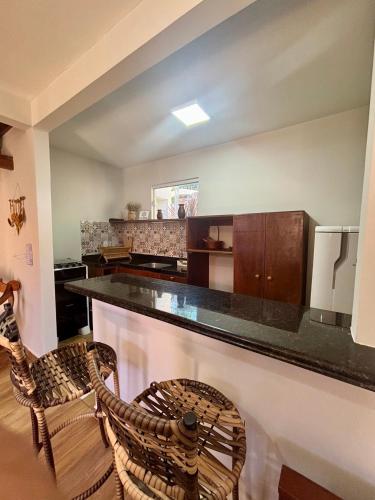 a kitchen with a counter and two chairs at Morada das Dunas in Atins