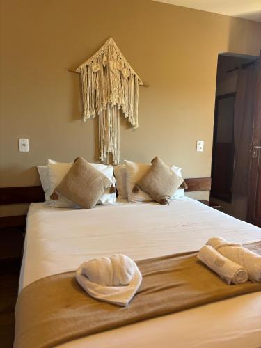 a bedroom with a bed with two towels on it at Morada das Dunas in Atins