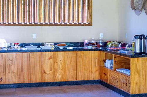 a kitchen with wooden cabinets and a counter top at Vila Preá in Prea
